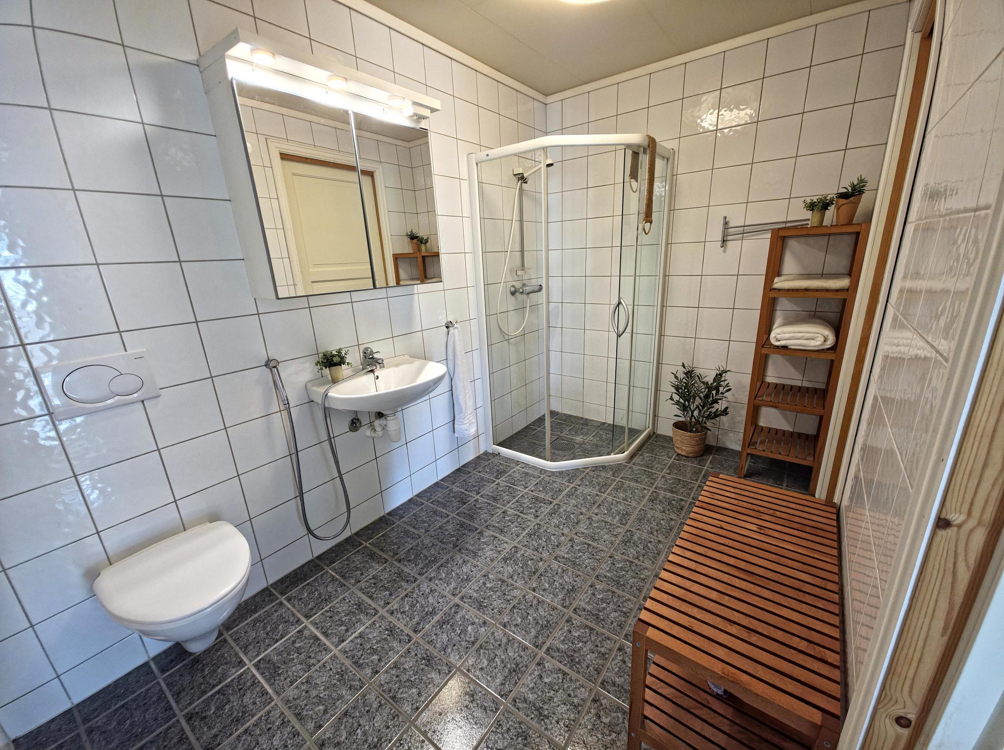 Lyst og fint flislagt bad med gulvvarme. Baderomsmøbler medfølger.